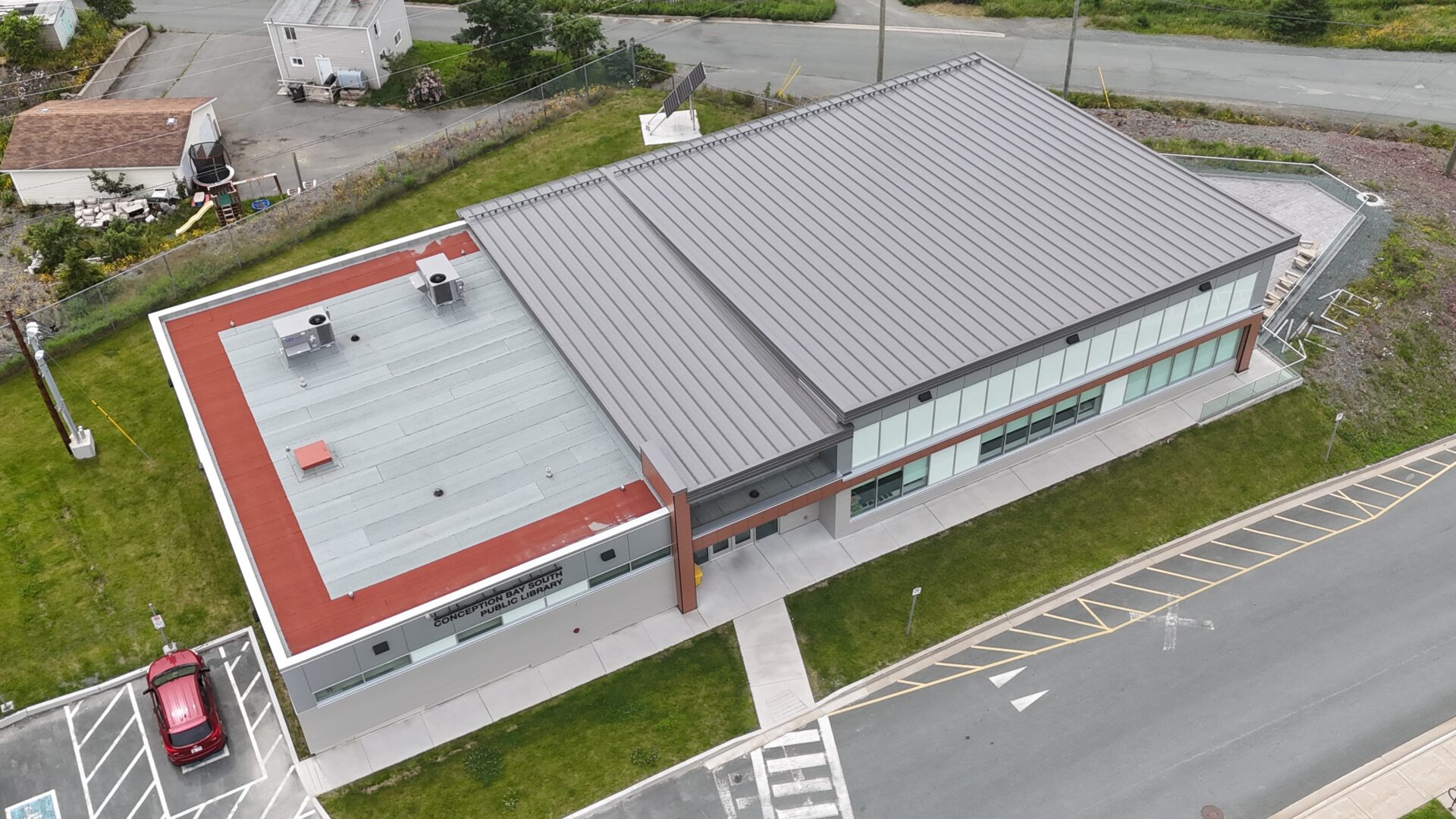The building has a unique design, with a metal roof and a red tiled roof