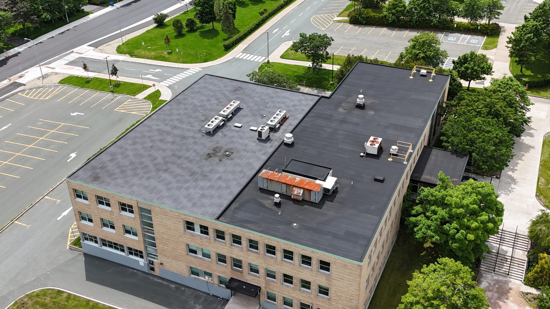Aerial view of a large building showcasing its expansive roof and surrounding landscape